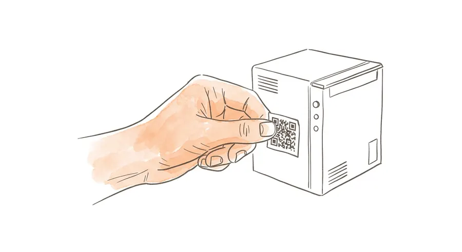 A hand sticking a QR label onto a machine
